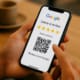 A Customer Is Using A Smartphone To Leave A Google Review, With A Qr Code Visible On The Screen, Which Can Enhance Local Seo And Improve The Business'S Visibility In Search Results. The Scene Emphasizes The Importance Of Online Reviews In Influencing Search Rankings And Attracting More Customers.